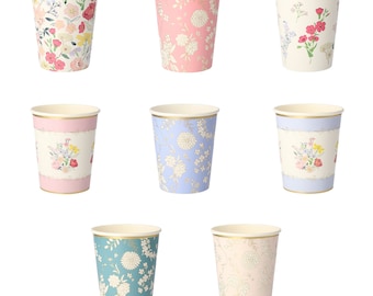 May include: Set of nine paper cups with floral patterns. The cups are in various colors, including pink, blue, and green. Each cup has a gold rim and a different floral design.
