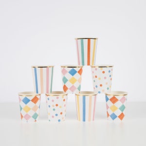 May include: Set of eight colorful paper cups with different geometric patterns, including stripes, polka dots, and diamonds. The cups have a gold rim and are perfect for a party or celebration.