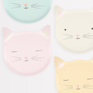 May include: Four paper plates with cat faces. The plates are in pastel colors: light blue, cream, pink, and yellow. Each plate has a different cat face with closed eyes and whiskers.