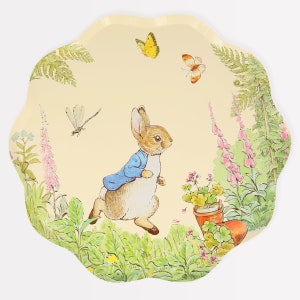 May include: A decorative, scalloped-edge tray featuring a whimsical illustration of Peter Rabbit running through a garden. The design includes butterflies, flowers, and a dragonfly, set against a cream-colored background.