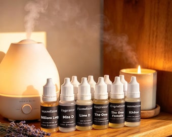 Puede incluir: Una colección de pequeños frascos cuentagotas de plástico transparente con tapas blancas y etiquetas negras, con textos como Milions Lady, Miss D, Lime D, The One, The One Female y Khdoe, junto a un difusor eléctrico blanco y una vela.