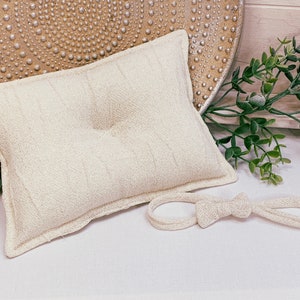 Newborn posing pillow with hair bow in natural beige. Baby photo shoot. Exclusive props photography.