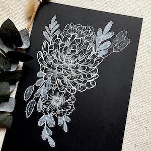 May include: White ink illustration of a bouquet of flowers on a black background. The flowers are stylized and include chrysanthemums, carnations, and other blooms. The artwork is signed "Alana" in the bottom right corner.