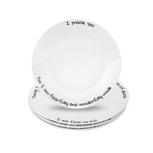 May include: Set of four white ceramic dinner plates with black handwritten text around the rim. The text reads "I praise You", "Though I am fearfully and wonderfully made", "I will fear no evil", and "of death".