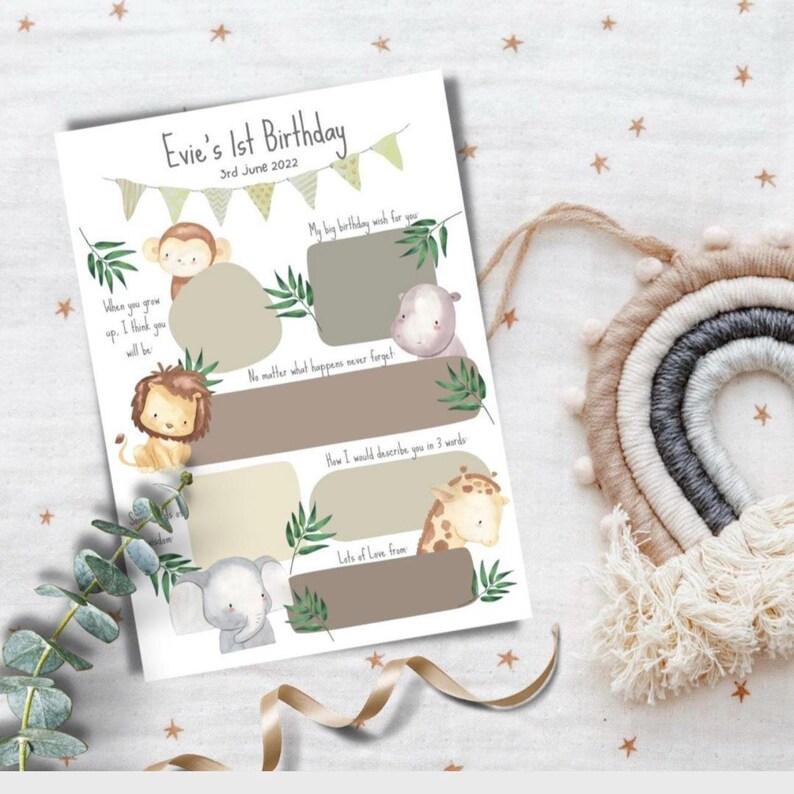 May include: A printable first birthday memory book with a jungle animal theme. The book has spaces for writing about the child's first year, including a birthday wish, a favorite memory, and a description of the child. The book features illustrations of a monkey, lion, elephant, hippopotamus, and giraffe.