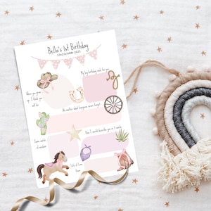 May include: A personalized birthday party invitation with a pink and beige cowgirl theme. The invitation includes illustrations of a cowboy hat, horseshoe, cactus, and a horse. The text reads "Bella's 1st Birthday".