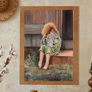 May include: A painting of a young girl sitting on a porch step, holding a white rabbit in her arms. The girl is wearing a green dress and has red hair. The painting is framed in wood.