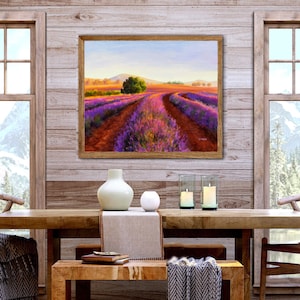May include: A framed painting of a lavender field with a dirt road leading through the center. The field is a vibrant purple and the sky is a soft blue. The painting is hanging on a wooden wall with two windows on either side.