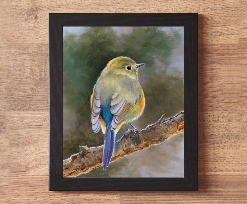 May include: A framed wall art print featuring a painting of a small bird with olive-green, yellow, and blue feathers perched on a textured brown tree branch. The bird is shown from behind, looking to the right. The frame is a simple black border.
