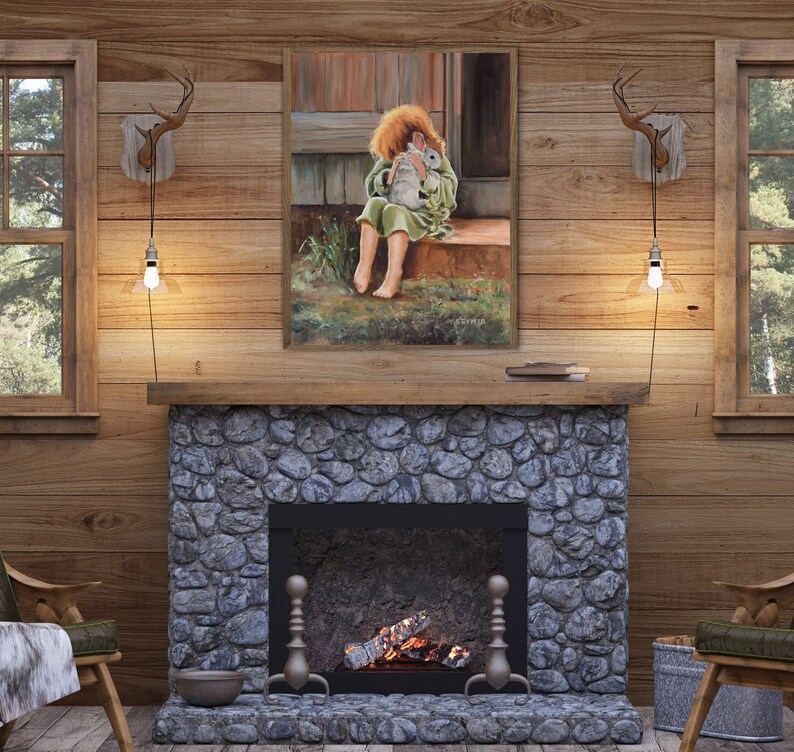 May include: A painting of a young girl sitting on a porch step, holding a white rabbit. The painting is framed in a wooden frame and is hanging on a wall in a rustic cabin.