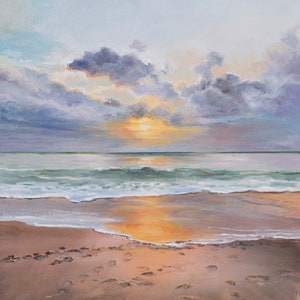 May include: An oil painting of a beach at sunset with a golden sun glowing behind dark purple and grey clouds. The ocean waves roll onto the sandy shore, reflecting the warm light. Footprints are visible in the wet sand in the foreground.