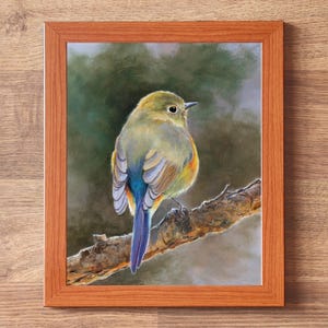 May include: A framed print featuring a painting of a small bird with olive-green, yellow, and blue feathers perched on a textured brown tree branch. The bird is shown from behind, looking to the right. The frame is made of light brown wood.