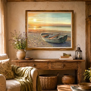 Op de afbeelding: Een ingelijst landschapsschilderij met een kleine roeiboot op een zandstrand bij zonsondergang. De sc&egrave;ne toont een kalme oceaan, een zachte gouden lucht en een houten boot met roeispanen. Het kunstwerk is geplaatst in een rustieke houten lijst.