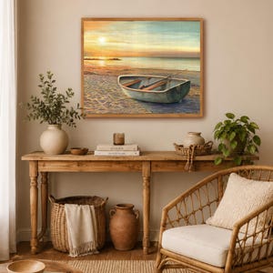 Op de afbeelding: Een rechthoekige ingelijste wandkunstprint met een kleine roeiboot op een zandstrand bij zonsondergang. Het schilderij toont een kalme oceaanhorizon, een zachte gouden lucht en een boot met houten roeispanen in een lichtgekleurde houten lijst.