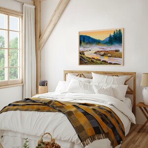 May include: A rectangular landscape painting in a light wood frame depicting a river flowing through a misty valley at sunrise. The scene features dark green pine trees, rocky riverbanks, and a golden sky reflecting on the water surface.