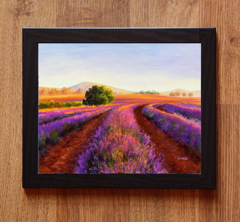 May include: A painting of a lavender field with a dirt road leading through it. The field is in bloom, with purple and pink flowers. The sky is blue and there are hills in the distance.