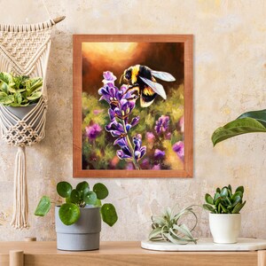 May include: A framed painting of a bumblebee pollinating a purple lavender flower. The painting is set against a warm, golden background and is framed in a dark wood frame.