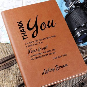 Może przedstawiać: Jasnobrązowy notatnik z czarnym tekstem: THANK YOU, IT'S PEOPLE LIKE YOU WHO MAKE WORK A NICER PLACE TO BE. Never forget THE DIFFERENCE YOU MADE, AND THE AMAZING PERSON YOU ARE. TEAM BEST 2025, ASHLEY BROWN.