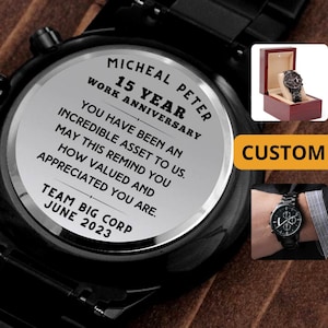 May include: A black metal wristwatch with a silver-toned back case engraved with the text: MICHEAL PETER 15 YEAR WORK ANNIVERSARY. YOU HAVE BEEN AN INCREDIBLE ASSET TO US. MAY THIS REMIND YOU HOW VALUED AND APPRECIATED YOU ARE. TEAM BIG CORP JUNE 2023.