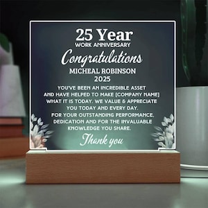 Peut inclure: Une plaque carrée en acrylique avec un fond dégradé vert foncé, montée sur une base rectangulaire en bois. Le texte indique 25 Year Work Anniversary Congratulations, Micheal Robinson 2025, avec un message d'appréciation et des motifs floraux.