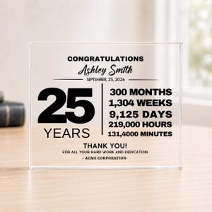 Può includere: Una targa rettangolare in acrilico trasparente con testo stampato in nero che recita CONGRATULATIONS Ashley Smith SEPTEMBER 25, 2026, 25 YEARS, 300 MONTHS, 1,304 WEEKS, 9,125 DAYS, 219,000 HOURS, 131,400 MINUTES, THANK YOU! FOR ALL YOUR HARD WORK AND DEDICATION - ACME CORPORATION.
