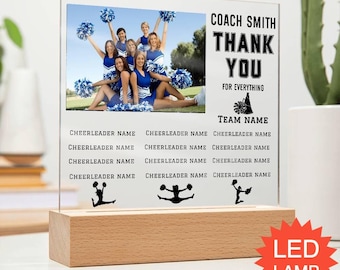 May include: A clear acrylic plaque set in a rectangular wooden base featuring a photograph of a cheerleading squad with blue uniforms and pom-poms. The text reads COACH SMITH THANK YOU FOR EVERYTHING TEAM NAME and includes placeholders for names.