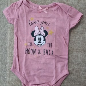 May include: Pink baby onesie with a black and white image of Minnie Mouse and the text "love you to the moon & back" in gold glitter.