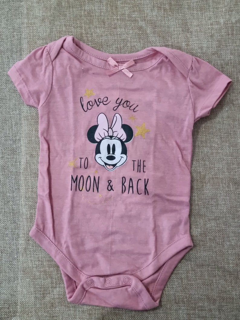 May include: Pink baby onesie with a black and white image of Minnie Mouse and the text "love you to the moon & back" in gold glitter.