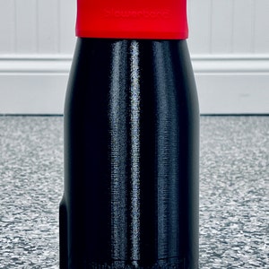 May include: A black power bank with a red silicone cap. The cap has the word "powerbank" printed on it.