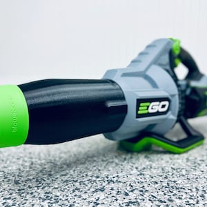 May include: A black and green leaf blower with the word "EGO" printed on the side. The blower has a green nozzle with the word "blower" printed on it.