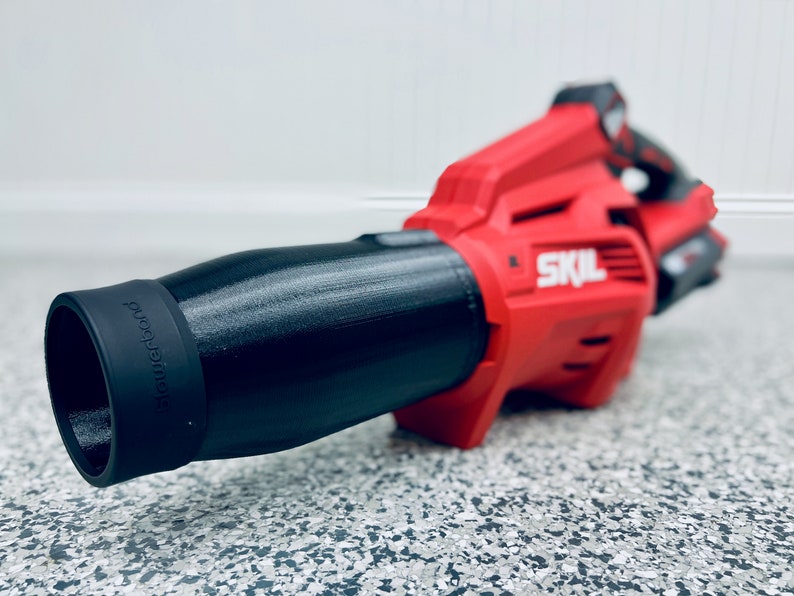 May include: A red and black cordless leaf blower with a black nozzle that says "blower" on it. The leaf blower is made by SKIL.