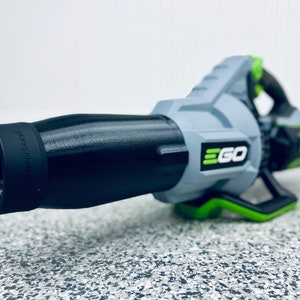 May include: A black and gray leaf blower with a green handle and the word "EGO" printed on the side. The blower has a black nozzle with the word "powerplex" printed on it.