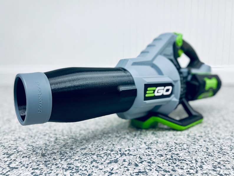 May include: A gray and black leaf blower with a green handle and the word "EGO" printed on the side. The blower has a black nozzle with a gray tip.