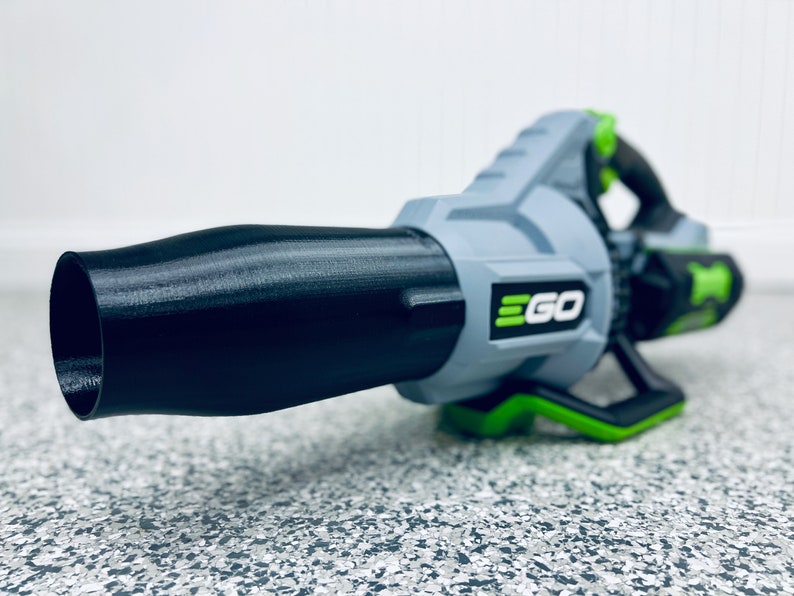 May include: A gray and green cordless leaf blower with a black nozzle. The blower has the word "EGO" printed on the side.