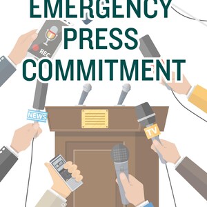 May include: A brown wooden podium with a gold plaque stands centered, surrounded by multiple hands holding various microphones and recording devices. The text EMERGENCY PRESS COMMITMENT is displayed in large dark green capital letters above.