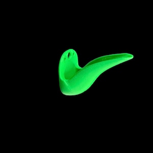 May include: A bright green plastic object with a curved spout and a small hole on the side. It is shaped like a bird's beak.
