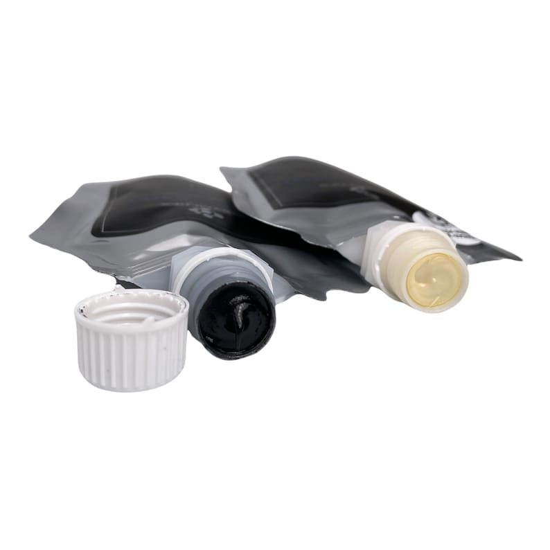 May include: Two tubes of paint with their caps off. One tube is black and the other is white.