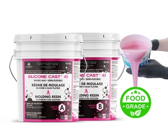 以下が含まれることがあります： 「Silicone Cast 45」と「NF Cast 45」とラベル付けされた、2つの白いシリコン鋳造樹脂のバケツ。バケツはそれぞれ10kgです。ピンクのシリコン樹脂が、1つのバケツから手袋をした手に注がれています。ラベルには、樹脂が食品グレード、半柔軟性、プラチナ硬化であることが記載されています。