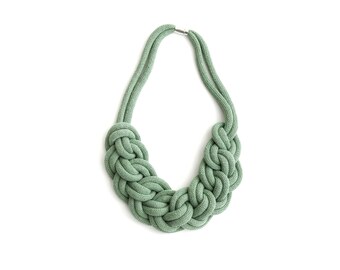 Op de afbeelding: Een saliegroene touwketting met een geknoopt ontwerp.