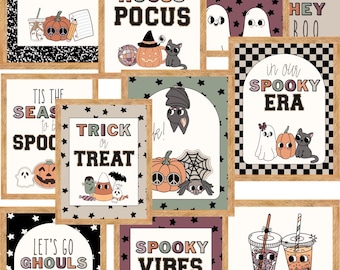 May include: A collection of framed Halloween-themed art prints. The prints feature various spooky designs, including pumpkins, ghosts, bats, and the phrases "Trick or Treat," "Hocus Pocus," and "Spooky Vibes." The frames are a light brown color.