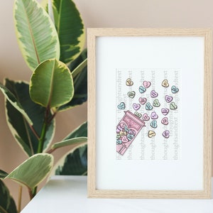 Op de afbeelding: Een ingelijst afdruk van een roze en witte snoepvaas met harten die eruit vallen. De harten zijn in verschillende tinten roze, blauw en groen. De tekst "thoughtsandtext" wordt herhaald in een kolom aan de rechterkant van de afdruk.