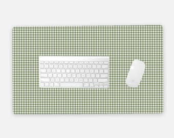 Pode incluir: Um teclado e um rato sem fios brancos estão sobre um tapete de secretária com padrão xadrez verde e branco. O tapete de secretária proporciona um espaço de trabalho elegante e funcional para uma configuração de computador.
