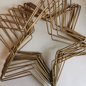 May include: A gold metal star-shaped wire frame, made of multiple layers of wire, creating a three-dimensional effect.