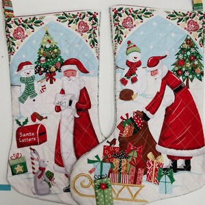 May include: A pair of white quilted Christmas stockings featuring a red and white Santa Claus, a snowman, and a hedgehog. The stocking on the right has a red and white Santa Claus carrying a bag of presents. The stocking on the left has a red and white Santa Claus holding a list. Both stockings have a blue and white background with a green and white border.