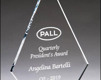 Op de afbeelding: Een heldere glazen award in de vorm van een diamant met een zwarte basis. De award is gegraveerd met de tekst "PALL" in een cirkel, "Quarterly President's Award", "Angelina Bartelli" en "Q2 - 2019".