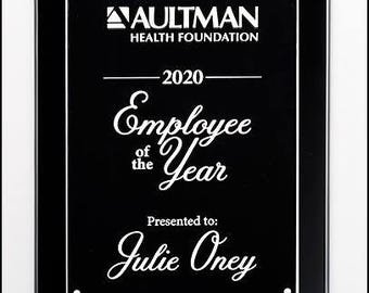 May include: Black plaque with white text. The text reads "Aultman Health Foundation", "2020", "Employee of the Year", "Presented to: Julie Oney".