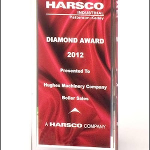 May include: A red and white acrylic award plaque with the text "HARSCO INDUSTRIAL Patterson-Kelley DIAMOND AWARD 2012 Presented To Hughes Machinery Company Boiler Sales A HARSCO COMPANY".