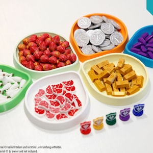 以下が含まれることがあります： さまざまな色と形をした205個のゲームピースのセット。コイン、金塊、イチゴ、肉、牛乳瓶、紫色のブロックなどがあります。ピースは5つの別々のボウルに配置されており、それぞれ異なる色をしています。画像の右上隅には「Komplettes Set」と「Full Set」のテキストが表示されています。