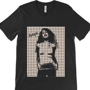 May include: Black t-shirt featuring a white graphic of a woman in a dotted pattern. The graphic says "Angie" in a stylised font.