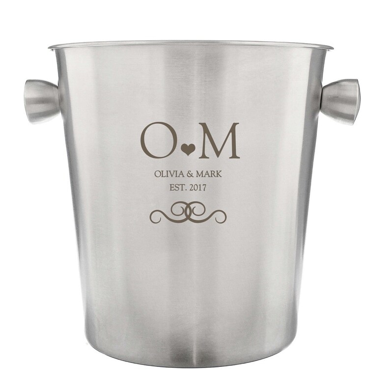 May include: Silver ice bucket with handles and engraved initials "O.M." with the text "Olivia & Mark Est. 2017" and a decorative swirl design.